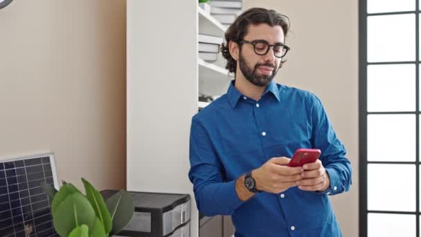 Młody Latynos Człowiek Biznes Pracownik Uśmiechnięty Pewnie Pomocą Smartfona Biurze — Wideo stockowe