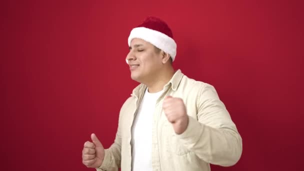 Młody Latynos Uśmiecha Się Pewnie Nosząc Świąteczny Kapelusz Tańcząc Odizolowanym — Wideo stockowe