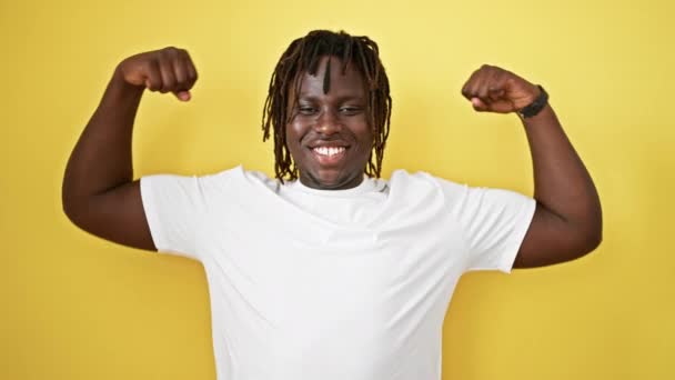 Африканский Американец Улыбается Уверенно Делая Сильный Жест Руками Изолированном Желтом — стоковое видео