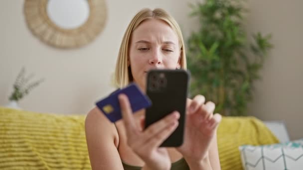 Молода Блондинка Купує Смартфоном Кредитною Карткою Сидячи Дивані Вдома — стокове відео