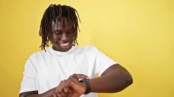 African American Man Smiling Confident Looking Watch Isolated Yellow Background — Stock Video