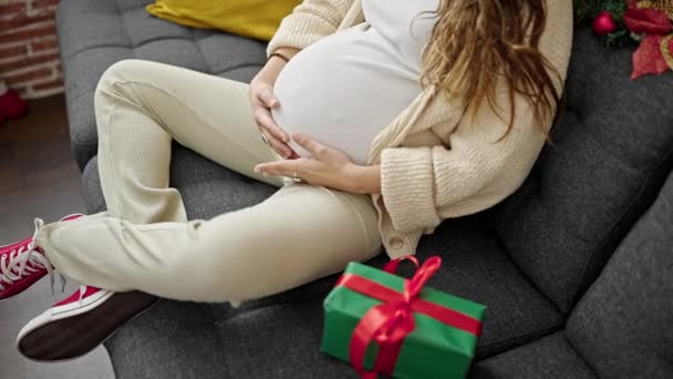 Jonge Zwangere Vrouw Aanraken Buik Zitten Bank Met Kerstcadeau Thuis — Stockvideo