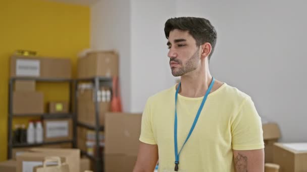 Jonge Spaanse Man Vrijwilliger Staat Met Serieus Gezicht Bij Liefdadigheidscentrum — Stockvideo