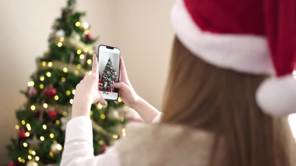 Mujer Rubia Joven Hacer Foto Árbol Navidad Por Teléfono Inteligente — Vídeos de Stock