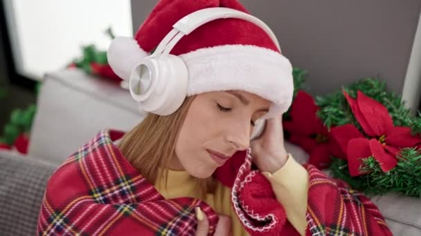 年轻的金发女人睡在家里的圣诞树旁的沙发上 — 图库视频影像