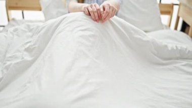 Young blonde woman smiling confident sitting on bed at bedroom