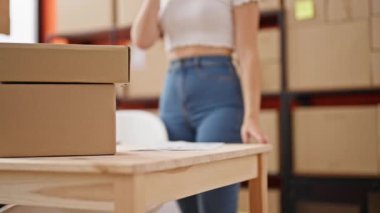 Genç sarışın kadın ecommerce iş işçisi ofisteki akıllı telefon okuma belgesiyle konuşuyor.