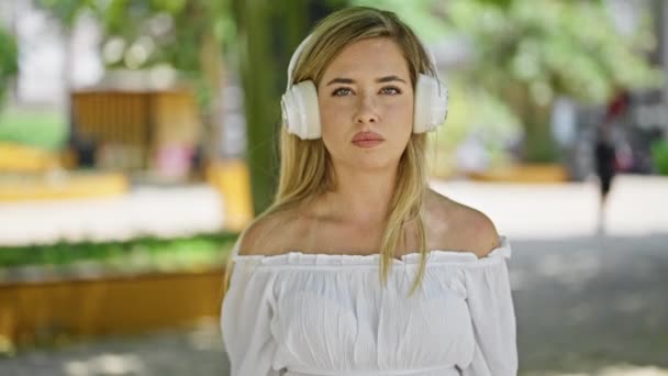 Junge Blonde Frau Nimmt Kopfhörer Und Sagt Mit Kopf Park — Stockvideo