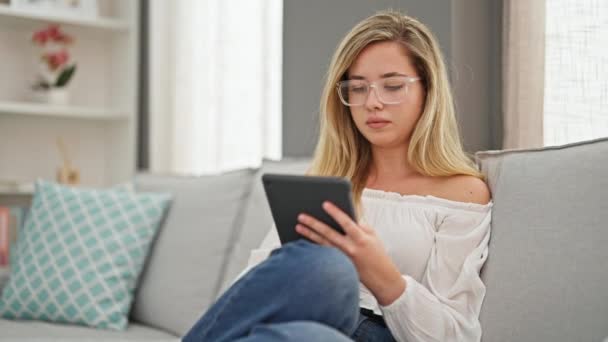 Mujer Rubia Joven Con Gafas Usando Touchpad Sonriendo Casa — Vídeo de stock