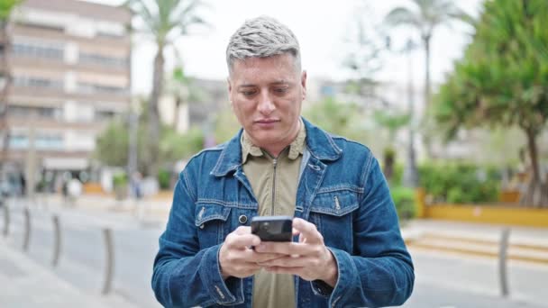 Giovane Uomo Caucasico Utilizzando Smartphone Con Espressione Grave Strada — Video Stock