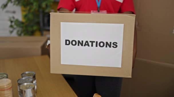Αφροαμερικανή Εθελόντρια Χαμογελά Αυτοπεποίθηση Κρατώντας Πακέτο Δωρεών Στο Γραφείο — Αρχείο Βίντεο