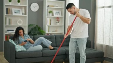 Kadın ve erkek evde akıllı telefon temizliği yapıyorlar.