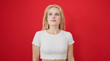 Genç sarışın kadın kendinden emin bir şekilde gülümsüyor.