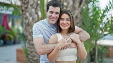 Güzel çift gülümsüyor. Parkta birbirlerine sarılıyorlar.