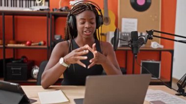 Afrikalı Amerikalı kadın muhabir müzik stüdyosunda video görüşmesi yapıyor.
