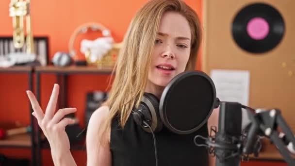 음악가가 스튜디오에서 자신감에 노래를 부르며 웃는다 — 비디오