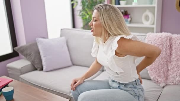 Young Blonde Woman Suffering Backache Sitting Sofa Home — Stock Video
