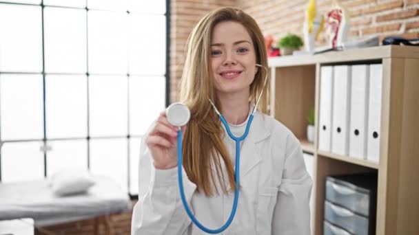 Ung Blond Kvinna Läkare Ler Säker Hålla Stetoskop Kliniken — Stockvideo
