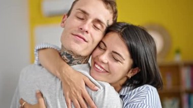 Güzel çift gülümsüyor. Kendilerine güveniyorlar. Evde öpüşüyorlar.