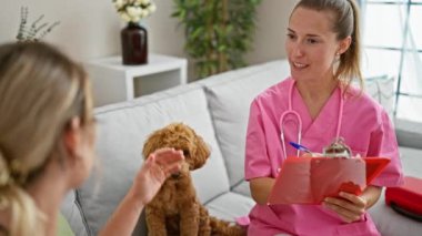 Köpek veterineriyle gülümseyen beyaz bir kadın veteriner kliniğinde notlar alıyor.