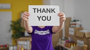 Genç ve güzel İspanyol kadın yardım merkezinde gülümseyen bir teşekkür mesajı tutuyor.