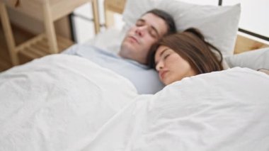 Yatakta uzanmış, yatak odasında uyuyan güzel çift.