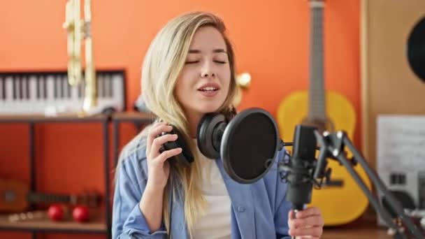 음악가가 스튜디오에서 자신감에 노래를 부르며 웃는다 — 비디오
