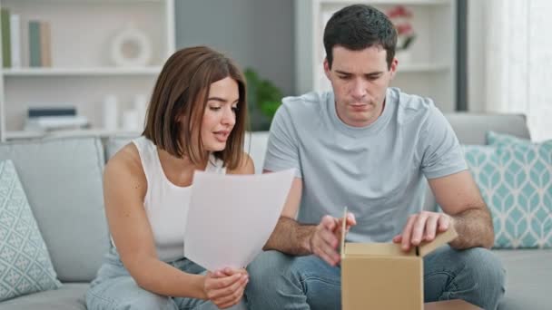 Beautiful Couple Reading Paper Unpacking Cardboard Box Home — Stock Video