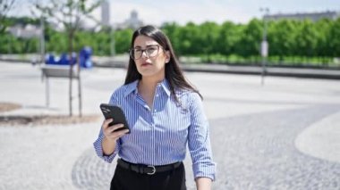 Madrid sokaklarında akıllı telefon kullanan genç ve güzel bir İspanyol kadın.