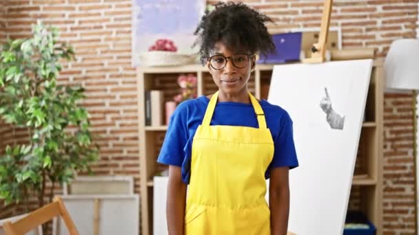 アフリカ系アメリカ人女性アーティストがアートスタジオで笑顔を交差させたジェスチャー — ストック動画