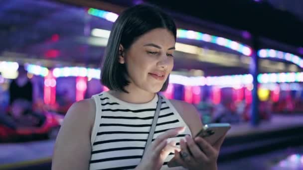 Νεαρή Όμορφη Ισπανόφωνη Γυναίκα Χαμογελά Ευτυχισμένη Χρησιμοποιώντας Smartphone Στο Prater — Αρχείο Βίντεο