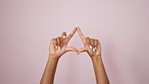 孤立したピンクの背景の上に手で三角形のジェスチャーをしているアフリカ系アメリカ人女性 — ストック動画
