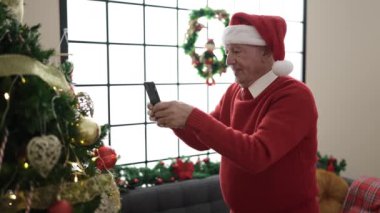 Son sınıf öğrencisi Noel 'i mutlu bir suratla akıllı telefondan kutluyor. Son sınıf öğrencisi Noel Baba 'yla video konuşmasını kutluyor. Kırmızı Noel Baba şapkalı son sınıf öğrencisi..