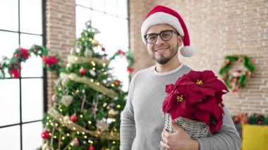 Kırmızı Noel Baba şapkalı bir adam evde noel hediyesiyle