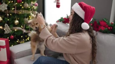 Noel zamanı Noel Baba şapkalı ve kazaklı mutlu genç bir kadın.      
