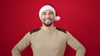 Genç Arap adam Noel 'i kırmızı arka planda kutluyor