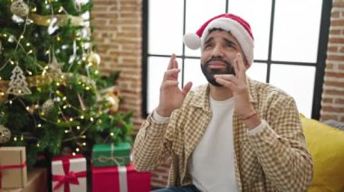 Noel Baba şapkalı yakışıklı adam evde Noel dileği diliyor.