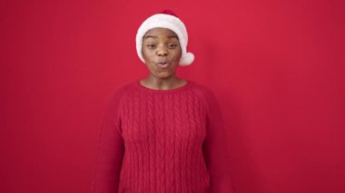 Genç Afrikalı Amerikalı kadın Noel 'i şaşırmış bir ifadeyle kutluyor.