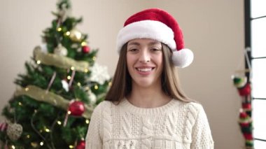 Noel Baba şapkalı güzel mutlu genç kadın evde Noel 'i kutluyor. 