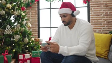 Yakışıklı adam Noel 'i kutluyor ve evde video oyunu oynuyor.