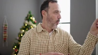 Olgun bir adam Noel 'i evde kutluyor ve yalnız dans ediyor. 