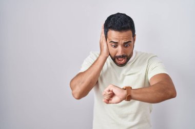 Sakallı İspanyol bir adam tecrit edilmiş geçmişine bakıyor. Saatin saatine bakıyor. Endişeli, geç kalmaktan korkuyor. 