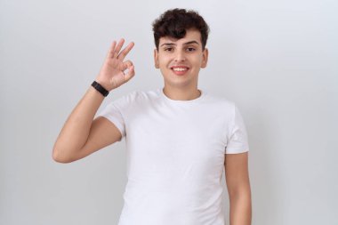 Gündelik beyaz tişört giyen, olumlu gülümseyen genç, el ve parmaklarıyla 