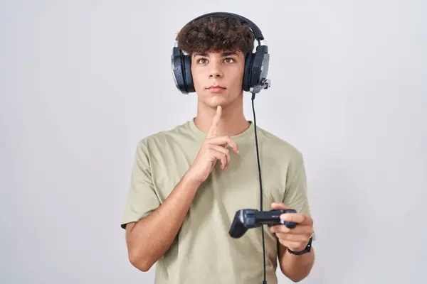 Hispanic Teenager Playing Video Game Holding Controller Thinking Concentrated Doubt — Stock Photo, Image