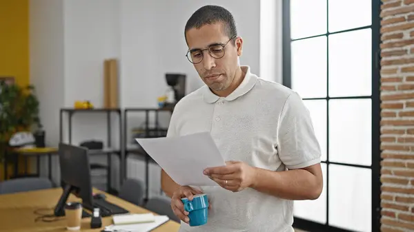 Mladý Hispánec Muž Obchodní Pracovník Pití Kávy Čtení Dokumentu Kanceláři — Stock fotografie