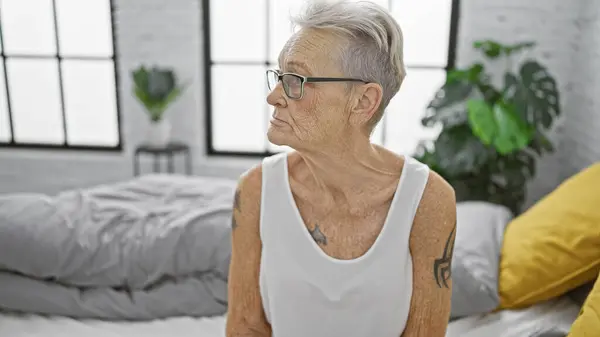 Serieus Uitziende Grijsharige Oudere Vrouw Comfortabel Ontspannen Haar Gezellige Bed — Stockfoto