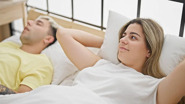 Beautiful couple covering ears for snore lying on bed at bedroom