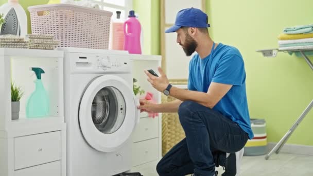 Νεαρός Ισπανός Τεχνικός Επισκευάζει Πλυντήριο Που Κρατάει Smartphone Στο Πλυσταριό — Αρχείο Βίντεο