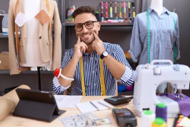 Sakal terzisi olan İspanyol bir adam atölyede çalışıyor ağzı açık gülümsüyor, parmakları işaret ediyor ve neşeli gülümsemeye zorluyor. 