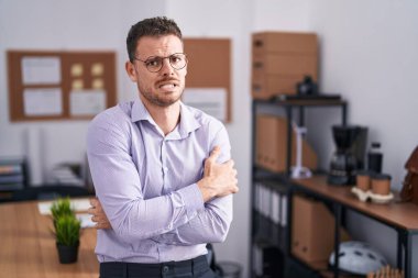 Ofisteki genç İspanyol adam yüzünde üzgün ve şok ifadesiyle kış soğuğu için titriyor ve donuyor. 